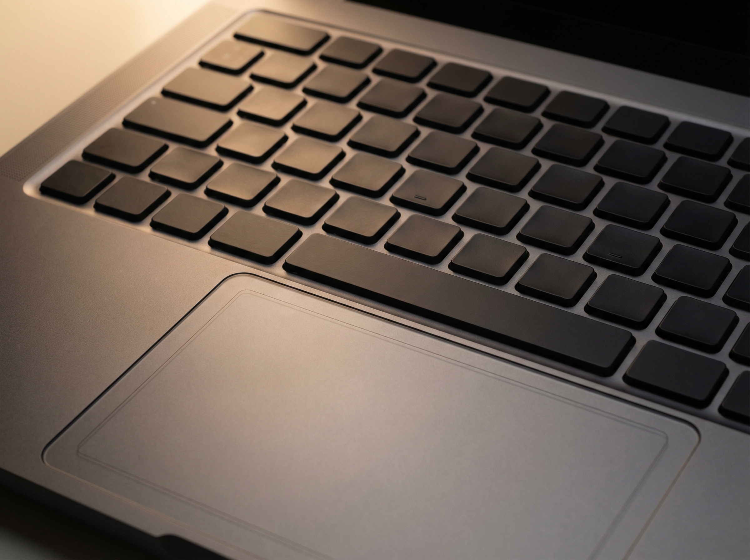 Close-up of a premium laptop keyboard with physical function keys and a haptic touchpad with subtle borders, high-quality metal finish, professional studio lighting, 4:3, no visible text